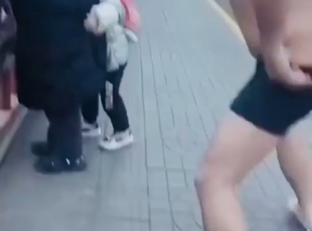 A man quickly removes his clothes and jumps into freezing water to rescue a stranger.