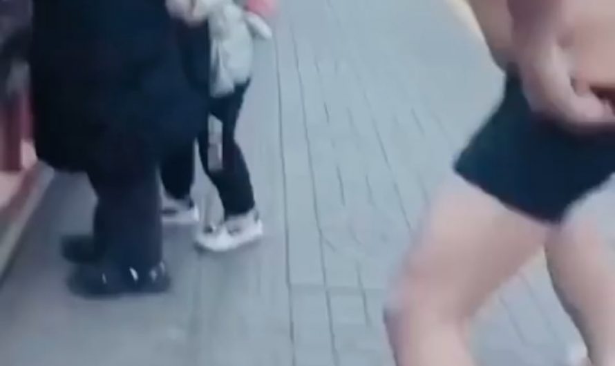 A man quickly removes his clothes and jumps into freezing water to rescue a stranger.