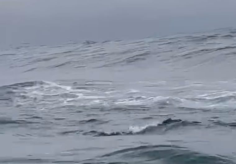 A surfer is carving the wave, and it looks unbelievably…