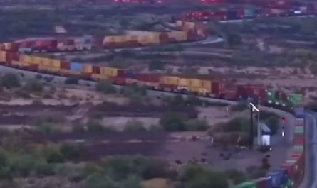 A very long train slowly slithering through the Mojave desert