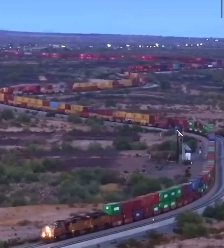 A very long train slowly slithering through the Mojave desert