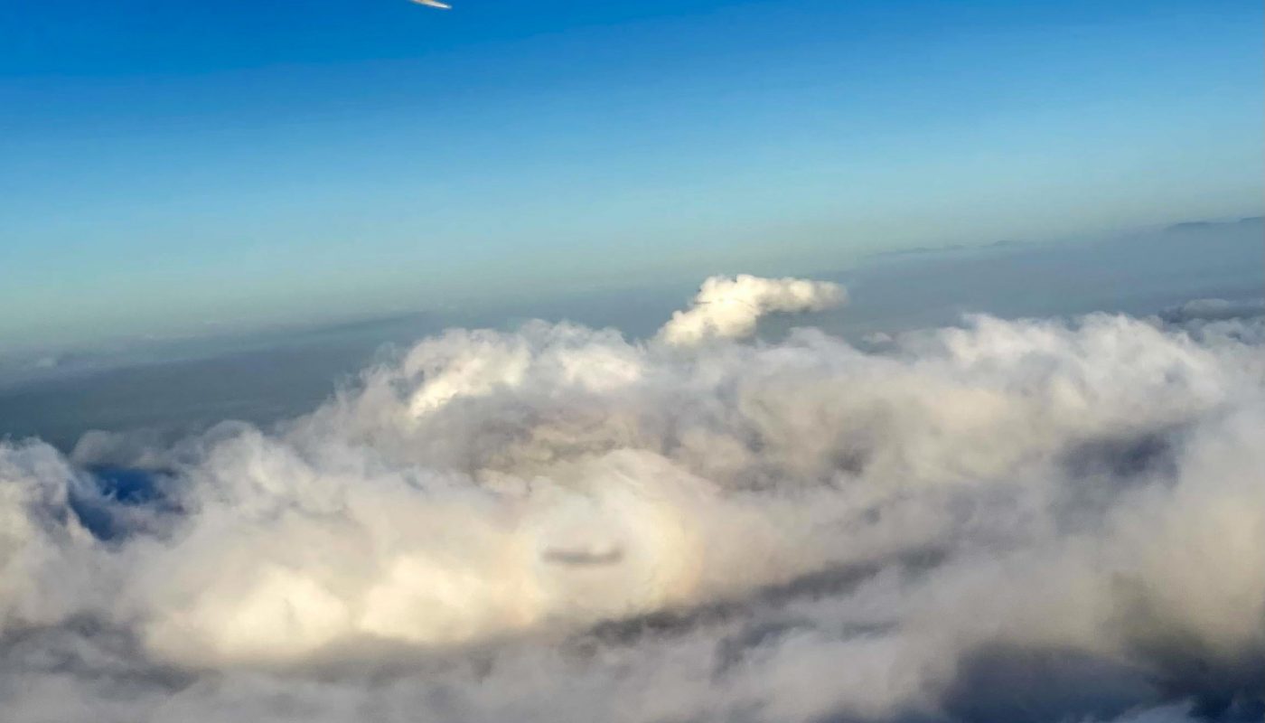 Airplane shadow on clouds surrounded by a halo