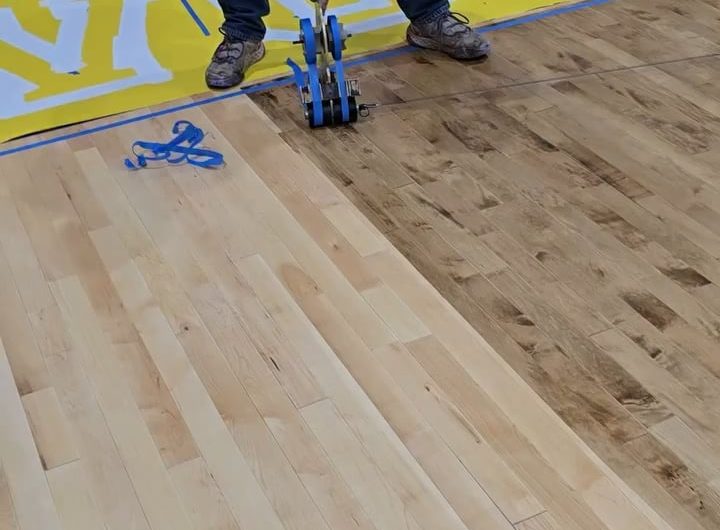 Applying masking tape on a basketball court