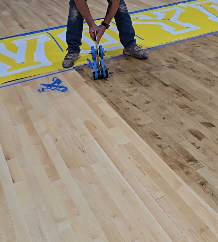 Applying masking tape on a basketball court