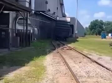 Derailed boxcar partially destroying a shed.