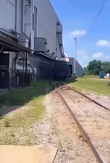 Derailed boxcar partially destroying a shed.