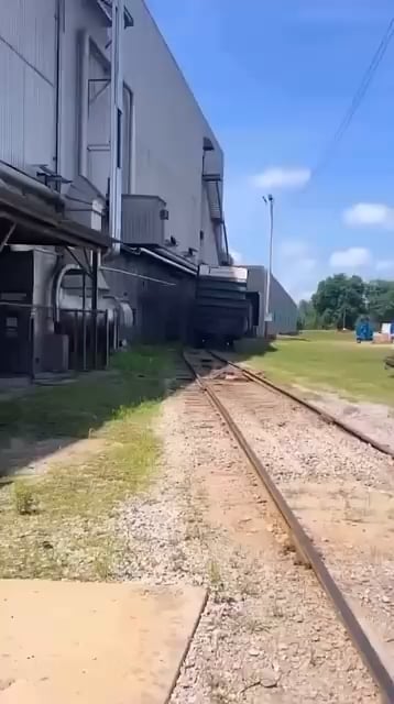 Derailed boxcar partially destroying a shed.