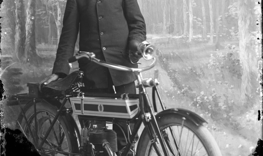 Glass negative of a man with his brand new Triumph motorcycle, circa 1900s.