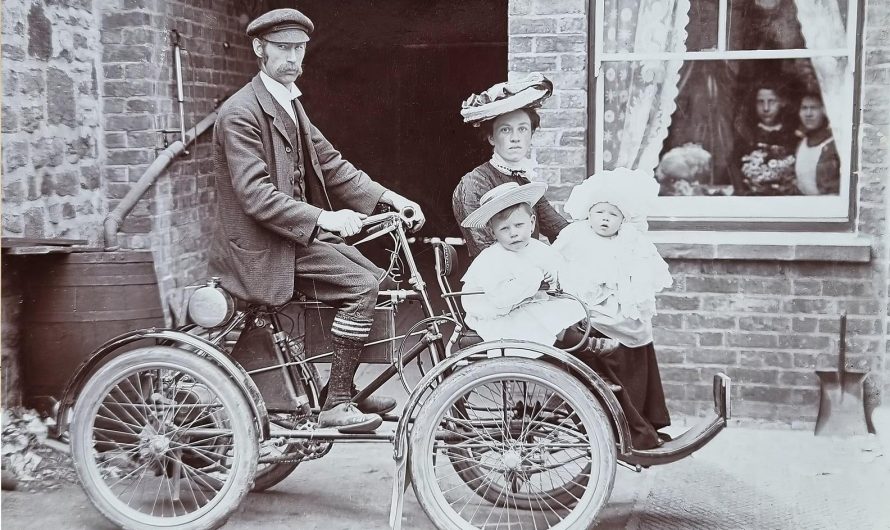 Man drives a early cyclecar (Fuel tank under him) and his family secure at the front, circa 1905-10