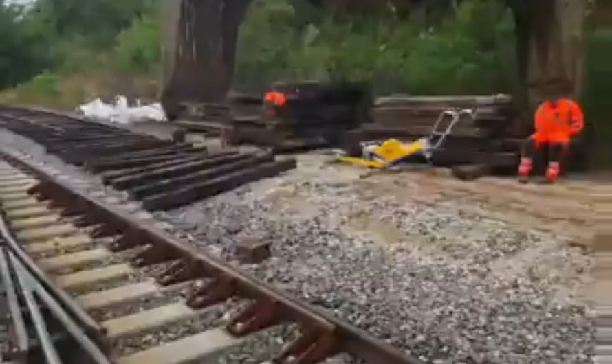 Railroad excavator doing alone the whole job of replacing the railway tracks.