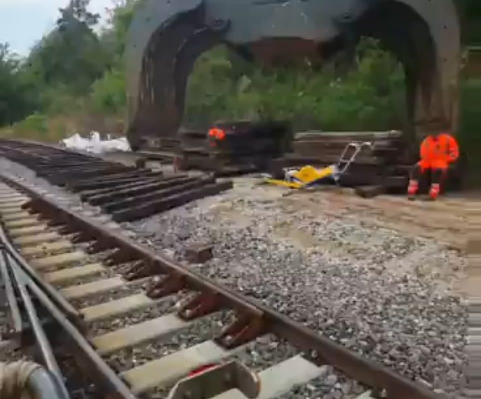 Railroad excavator doing alone the whole job of replacing the railway tracks.