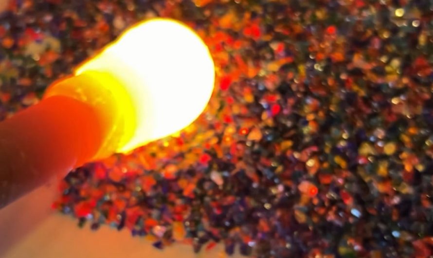 Rolling through pieces of colored glass to make an ornament.