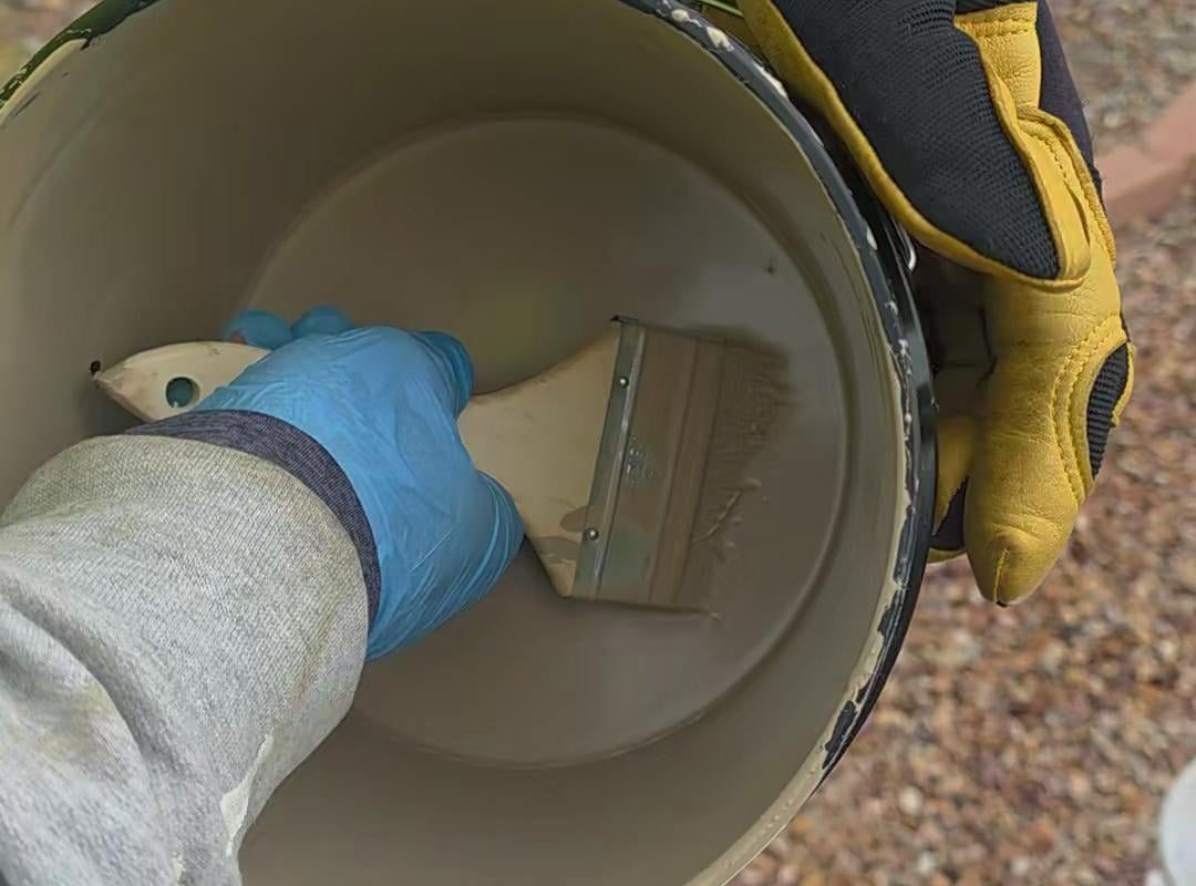 Taking out paint brush from a paint bucket