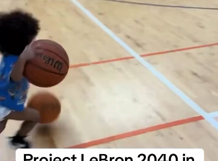 Toddler dribbling two basketballs on either hand