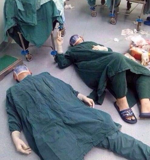 Two surgeons collapse on the floor from exhaustion after a 32-hour surgery to save a life by removing a patient’s brain tumors.