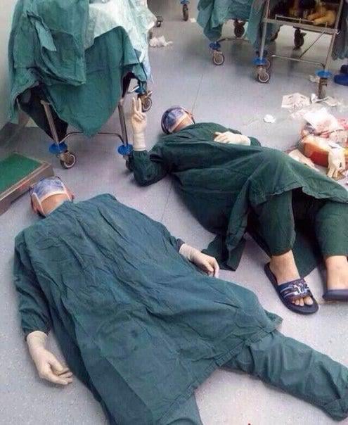 Two surgeons collapse on the floor from exhaustion after a 32-hour surgery to save a life by removing a patient's brain tumors.