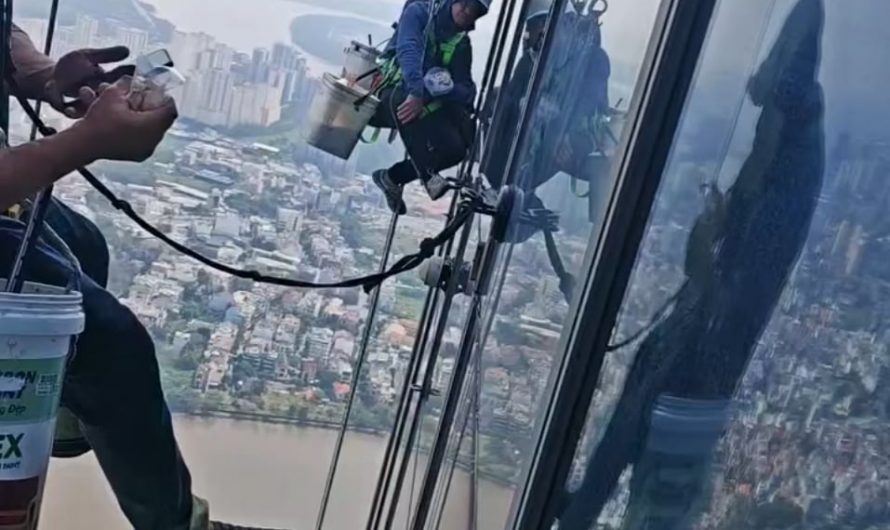 Window cleaners having breakfast and watching Tiktok while dangling outside of the tallest skyscraper in Vietnam