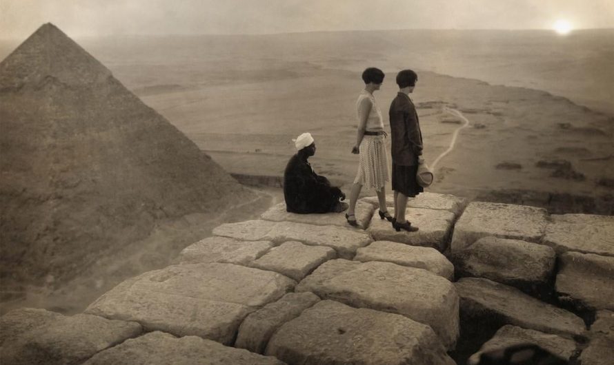 2 flappers look the sunset from the top of one of the Pyramids, circa 1920s.
