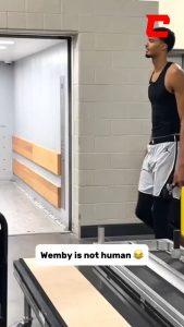 7'4 NBA player, Wemby, casually stepping over a regular-sized crowd barrier.