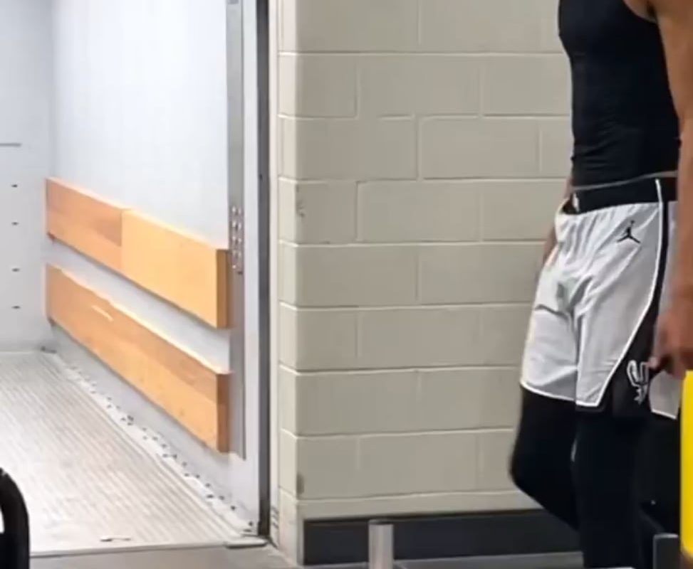 7'4 NBA player, Wemby, casually stepping over a regular-sized crowd barrier.