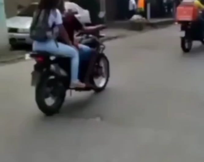 A biker balancing a tray of fruit salad for delivery