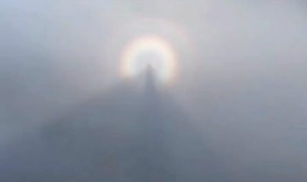 A hiker captures his own shadow floating in the mountain mist, surrounded by a bright solar halo. An unusual but completely natural phenomenon.