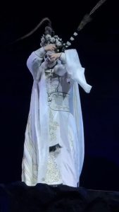 A performer changing masks into different characters with  a wave of their hand