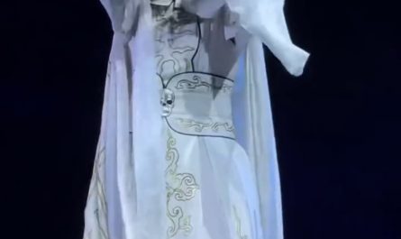 A performer changing masks into different characters with  a wave of their hand