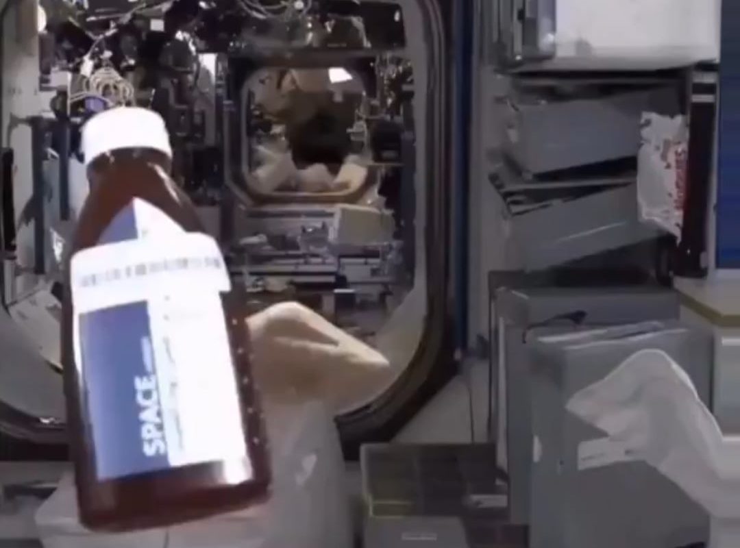 Astronaut eating bread and honey in space.