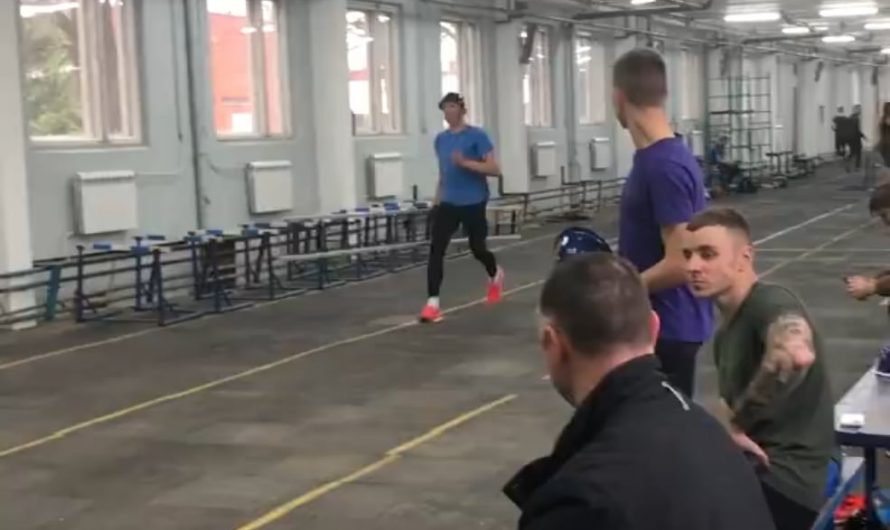 Competitive firefighter climbs up ladder.