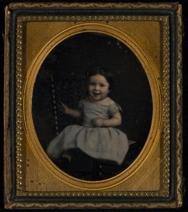 Daguerreotype of a little girl laughing. By this point a photo took 10-15 seconds (not minutes, that is a myth) and could capture some snap shot moments. Photo circa 1850s.
