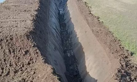Digging trench with excavator fitted with a V-shaped bucket