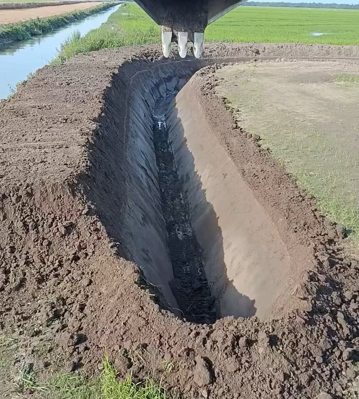 Digging trench with excavator fitted with a V-shaped bucket
