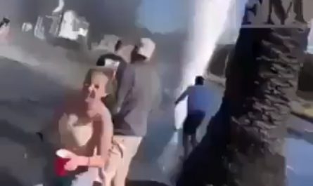 Group attempts a daring stunt with a burst water pipe geyser.