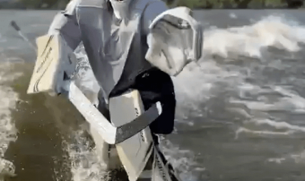 Hockey goalie coach surfing off boat