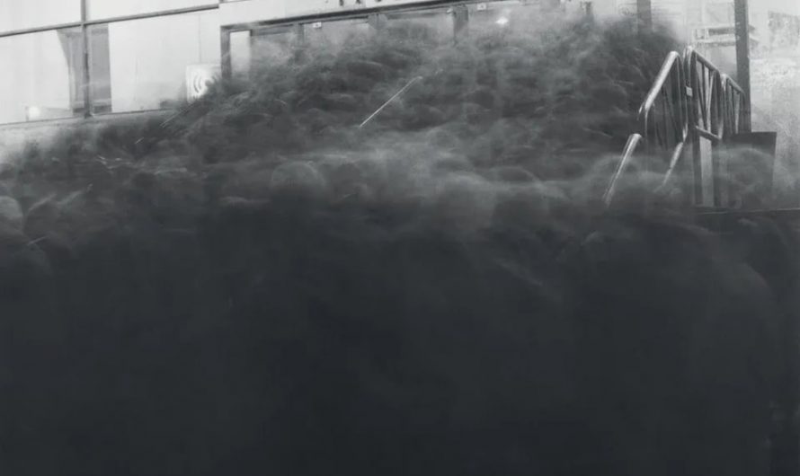 Long exposure photograph of a crowd near the entrance to the Vasileostrovskaya subway station in Saint Petersburg (1991) by Russian photographer Alexey Titarenko from the book “City of shadows”