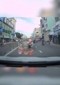 Motorbike cop maneuvering through heavy traffic in Vietnam to escort a woman in labor to the hospital