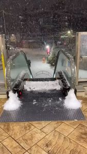 Outdoor escalator accumulating snow on the top step
