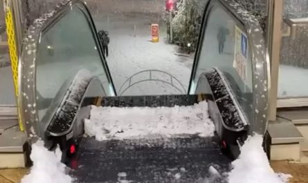 Outdoor escalator accumulating snow on the top step