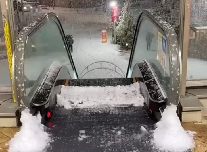 Outdoor escalator accumulating snow on the top step
