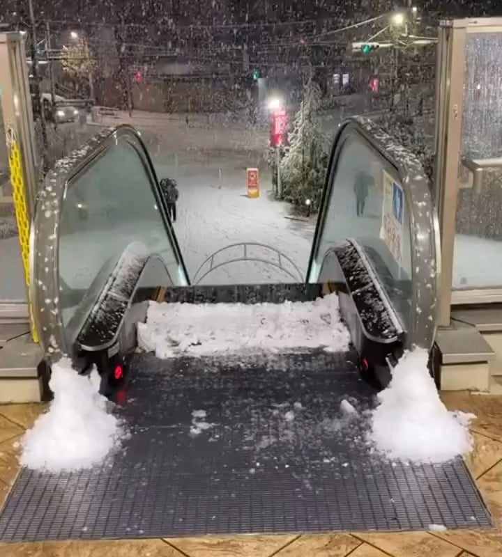 Outdoor escalator accumulating snow on the top step