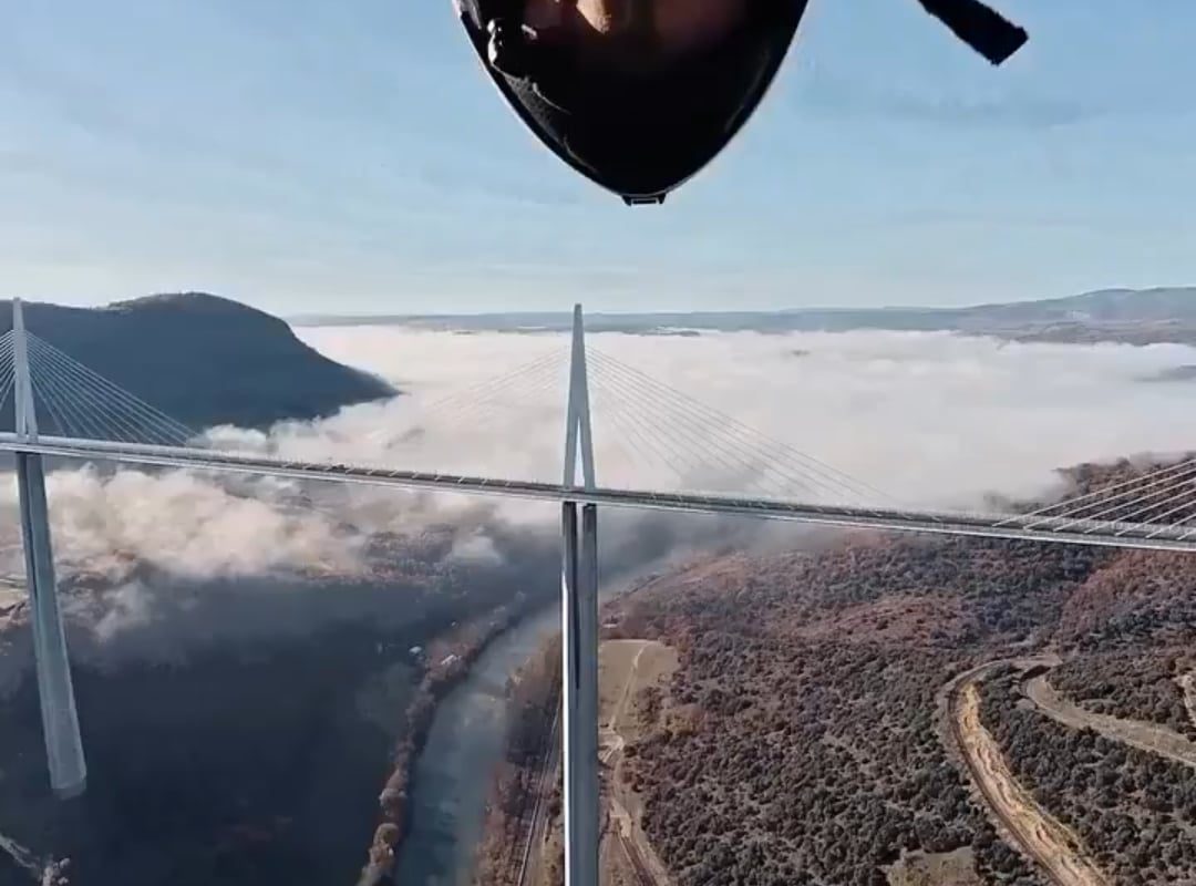 POV from a wingsuit of going in between an arch of a bridge