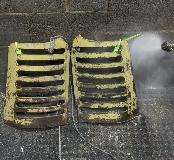 Pressure washing the paint and rust off this tractor grill after a chemical alkaline bath then an acid bath.