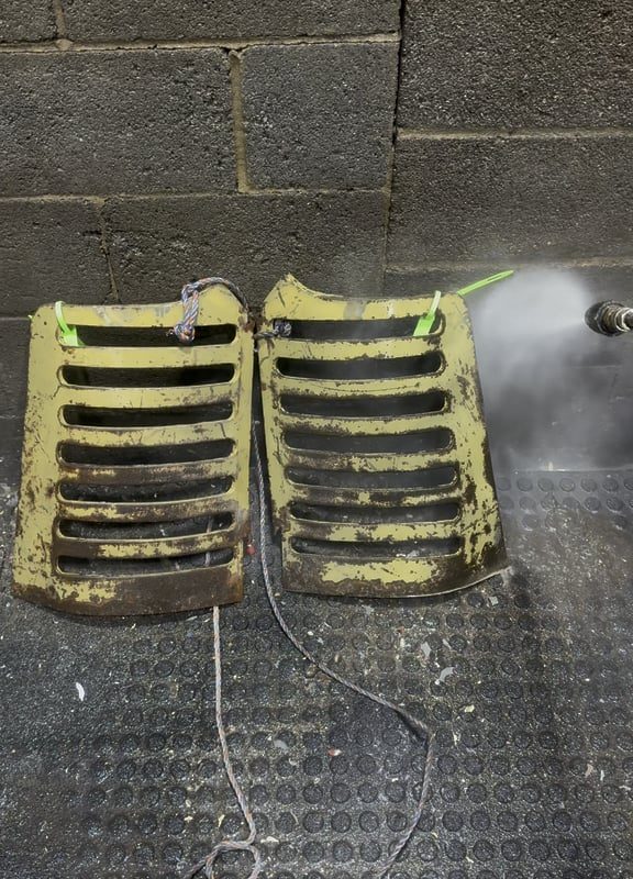 Pressure washing the paint and rust off this tractor grill after a chemical alkaline bath then an acid bath.