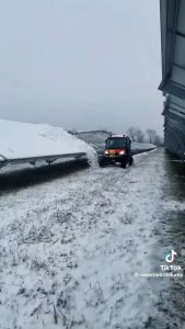Snow tractor removes snow off of the solar panel