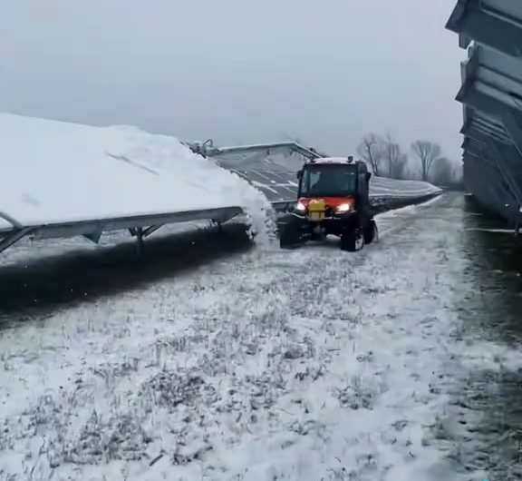 Snow tractor removes snow off of the solar panel