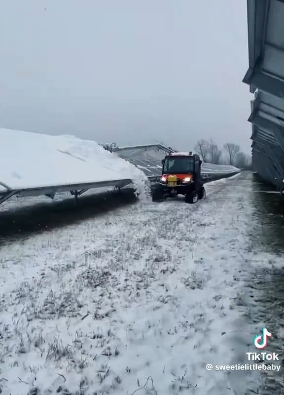 Snow tractor removes snow off of the solar panel