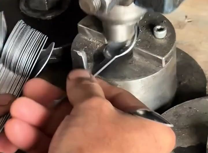 Spoons being pressed into shape