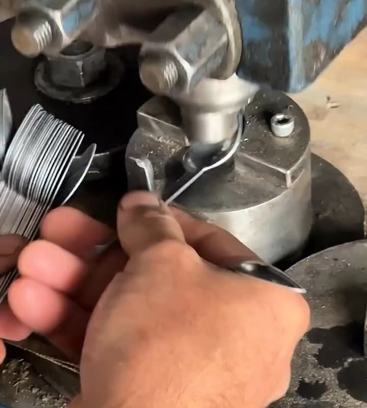 Spoons being pressed into shape