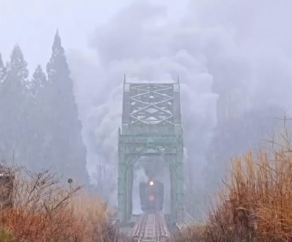 Steam Train crossing a Bridge in the Snow.